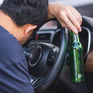    Drunk driver passed out on the steering wheel with a beer bottle. Title: Truck Accidents – DUI.