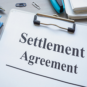   Close-up of a Settlement Agreement document on a clipboard. Title: Truck Accidents – Low Settlement Offers.  